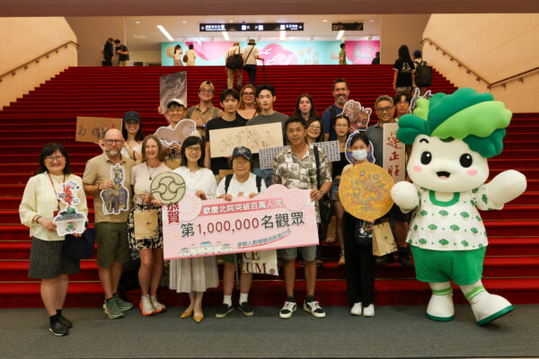 故宮北院慶祝2026年參觀人次突破百萬，幸運觀眾與故宮吉祥物小翠及工作人員合影。