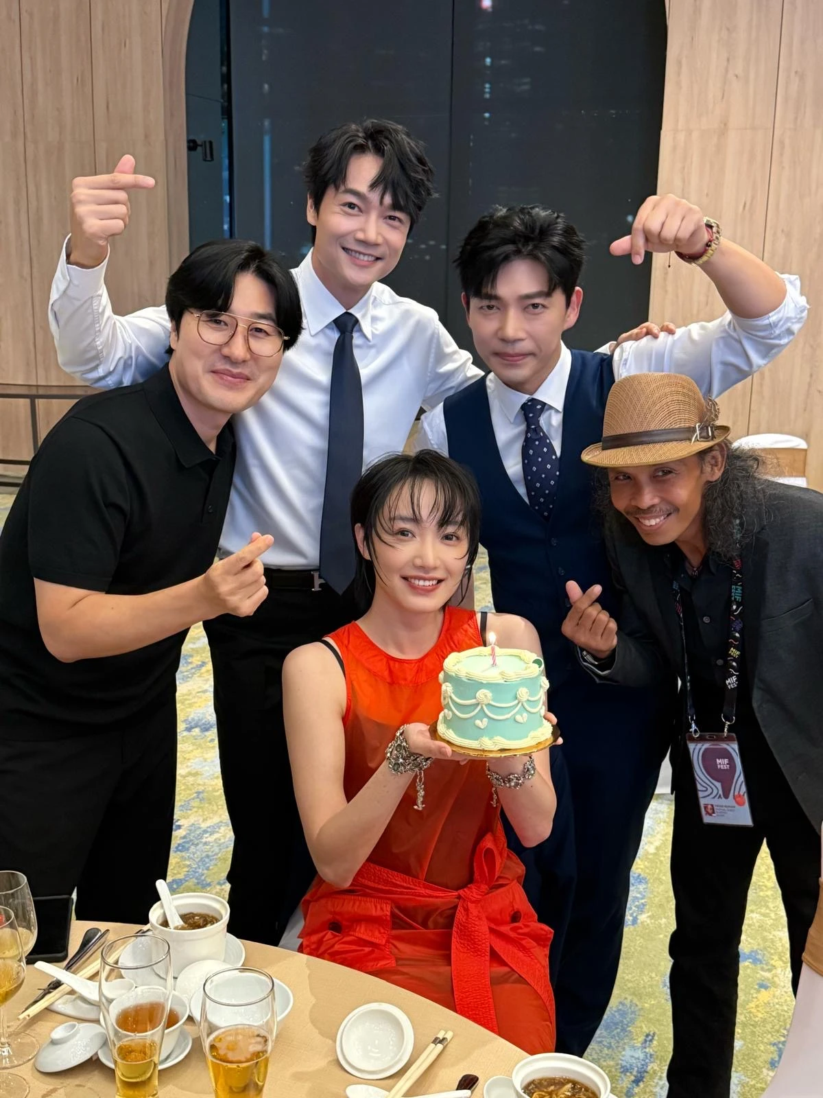 蔡思韵手捧生日蛋糕，與池承炫等劇組人員開心合影