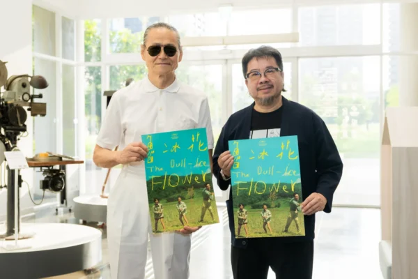 導演楊立國（左）與影視聽中心董事長褚明仁（右）手持《魯冰花》數位修復版海報合影。