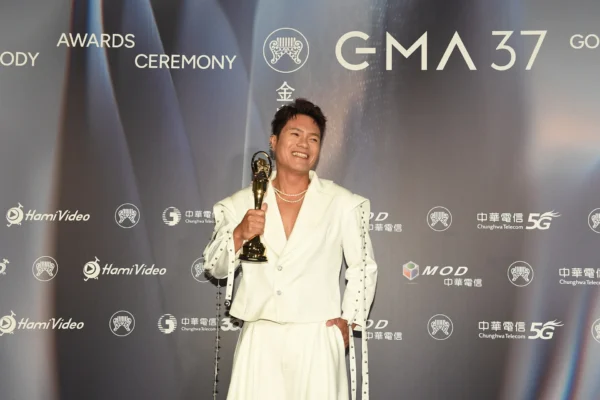 舒米恩手持金曲獎座，身穿白色西裝。