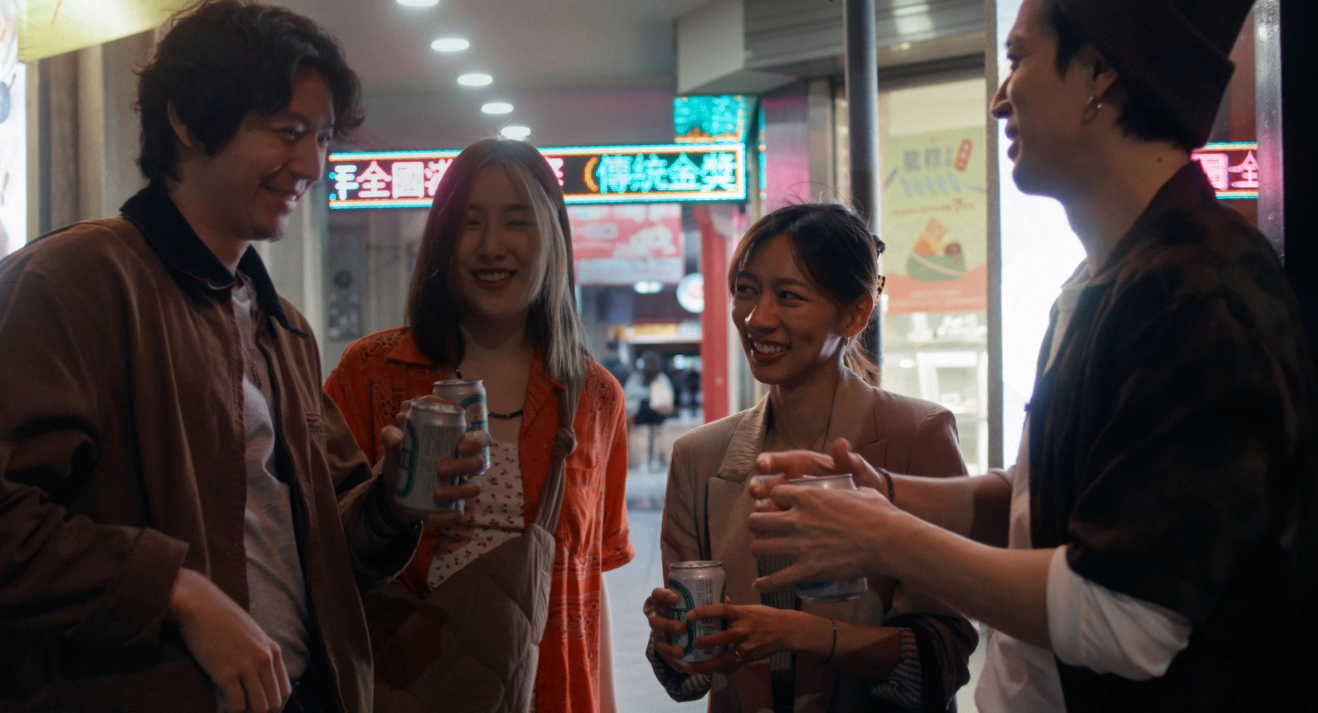 演員侯彥西、陳妤、毛祁芸、郭子豪在台北街頭夜間漫步,手持飲品互動。
