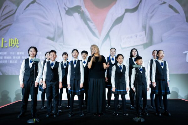 曾淑勤與拉縴人少年兒童合唱團於《魯冰花》首映會現場演唱主題曲。