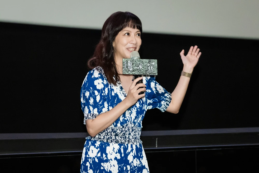 演員李淑楨手持麥克風在映後分享時微笑發言。
