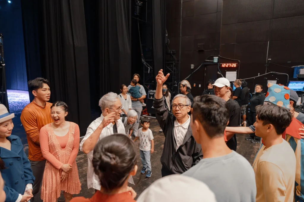 導演吳念真在後台向林懷民及劇組人員說話,眾人圍繞聆聽