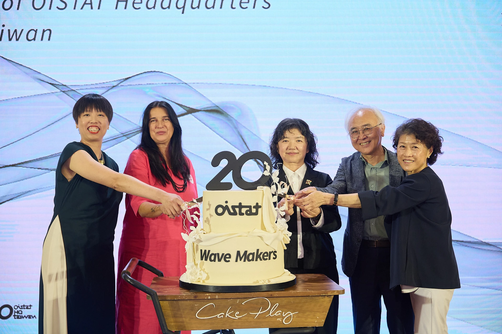 五位貴賓站在寫有「20」與「Wave Makers」的雙層週年蛋糕前準備切蛋糕，左起為魏琬容、Aby Cohen、李靜慧、楊其文、邱瑗。