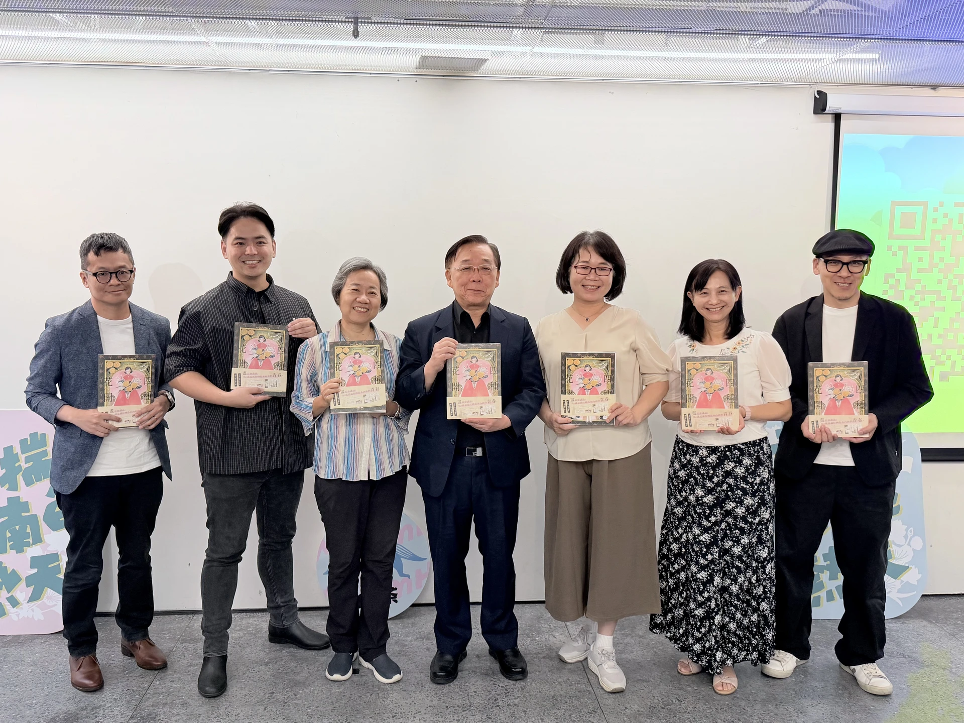 多位貴賓與學者在「食茶」講座中手持《四種花開》書籍合影,包含館長洪世佑、副館長周彥汝、聯經出版副總經理王聰威、原作者楊儒強、翻譯陳豐惠、書籍審定洪淑昭等人。