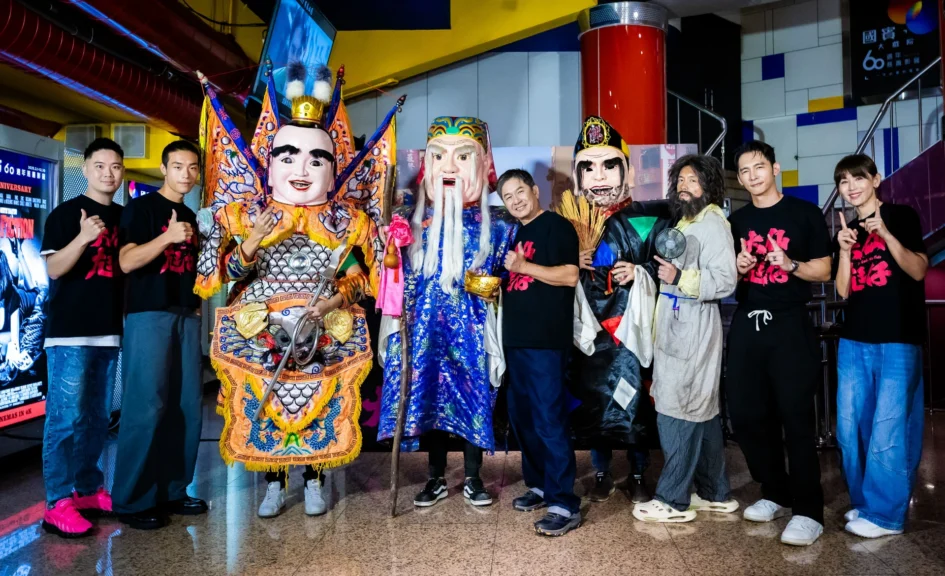 導演凌柏瑋與演員范逸臣、溫昇豪、洪都拉斯、鄭仲茵、牧森等人，與片中裝扮的太子、土地公、濟公三尊大仙尪仔在首映會背板前合影。