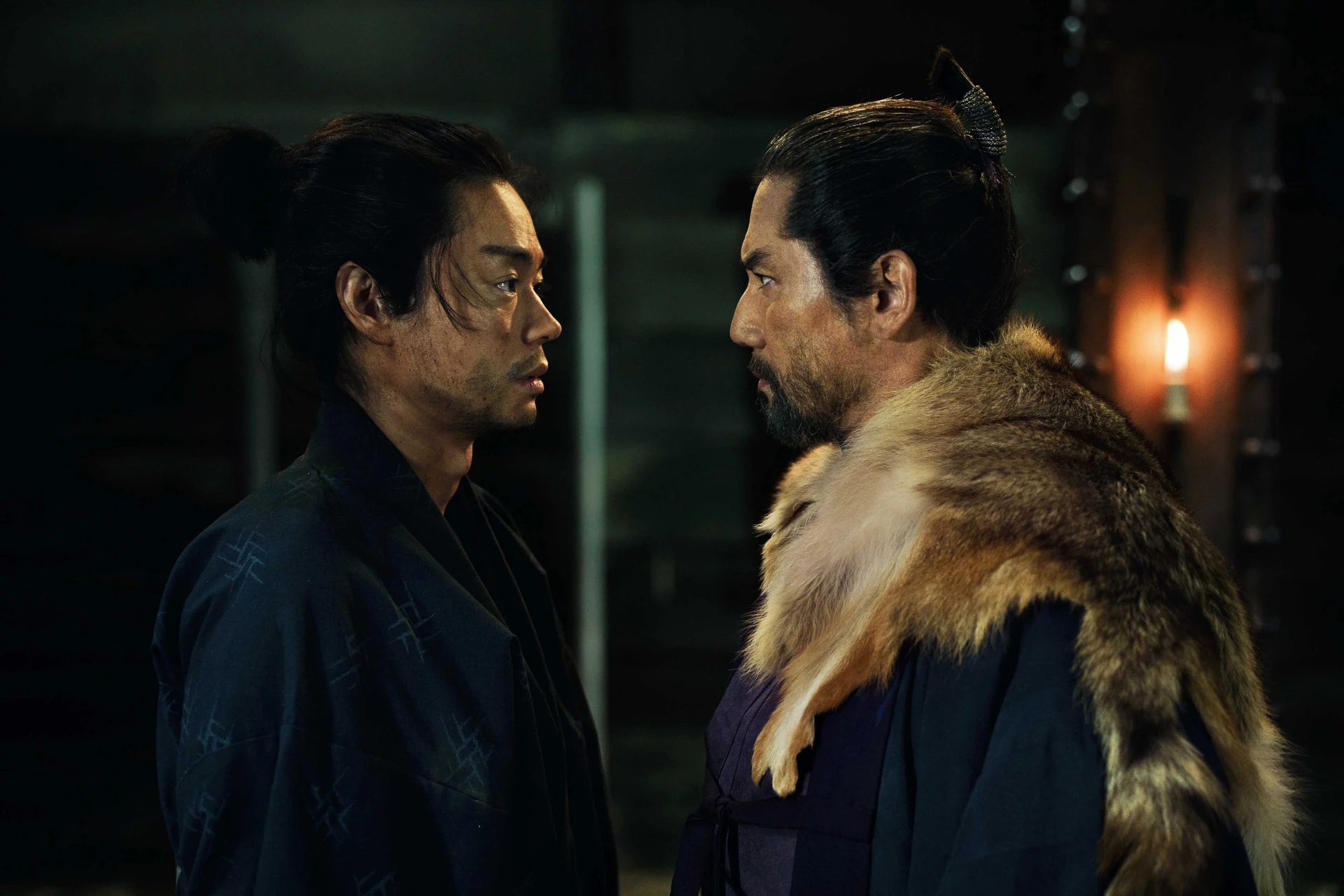 兩名古代男子在昏暗空間中面對面站立,互相注視對方,神情嚴肅。